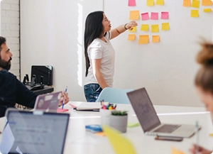 instructor leading a class with sticky notes on a white board